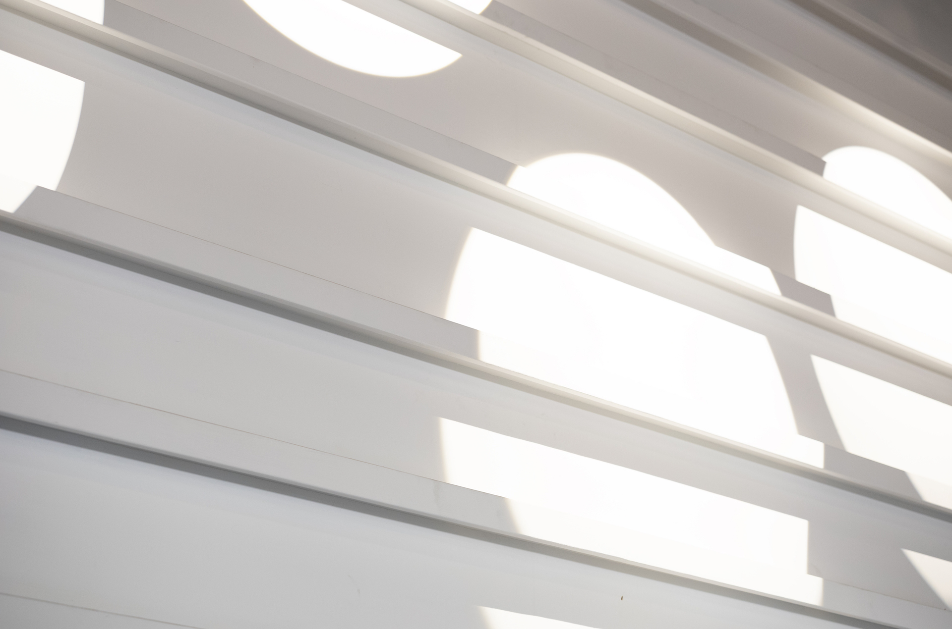 The tall glass windows of A39-1 with lush greenery outside and warm light inside